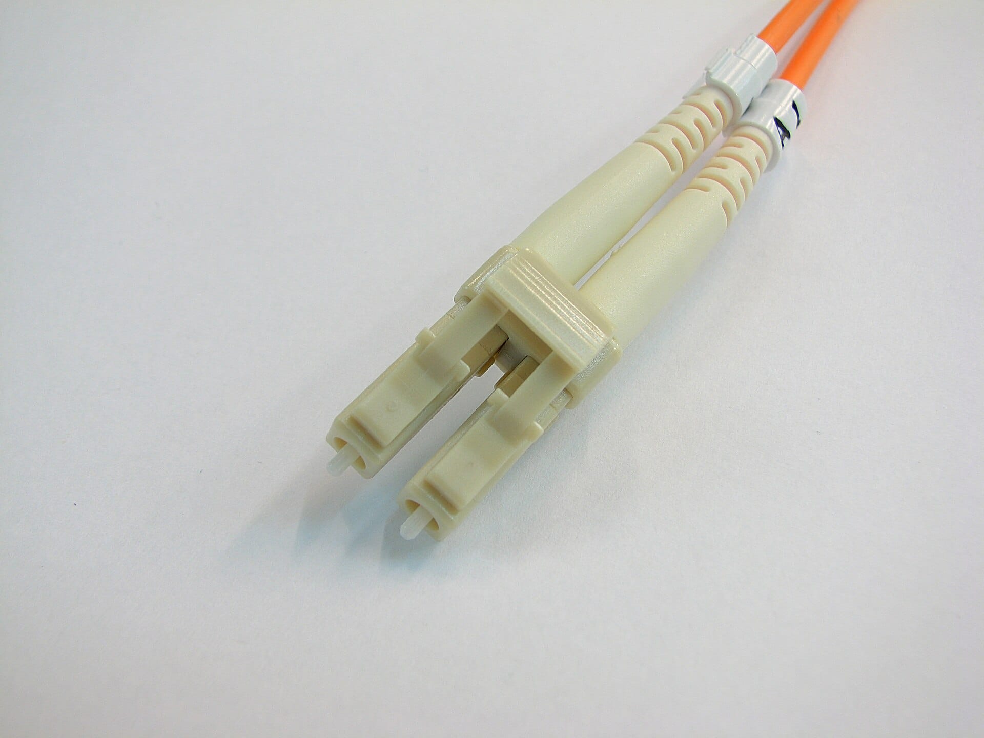 Close up photograph of an LC optical fibre connector showing its small latching body and the precision ferrule that carries the fibre core.